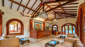 A lobby with a reception desk, seating area, and arched windows. - Resort Terra Paraiso (Calangute)