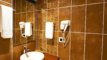 A bathroom with a sink, two towel hooks, a mirror, and a hairdryer.