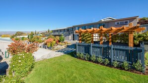 A modern residential building with a covered outdoor area, a well-maintained lawn, and a clear view of the surrounding landscape. - Central Gateway Motel (Cromwell)
