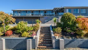 A modern building with a reception area, a staircase leading to a balcony, and a landscaped garden with various plants. - Central Gateway Motel (Cromwell)