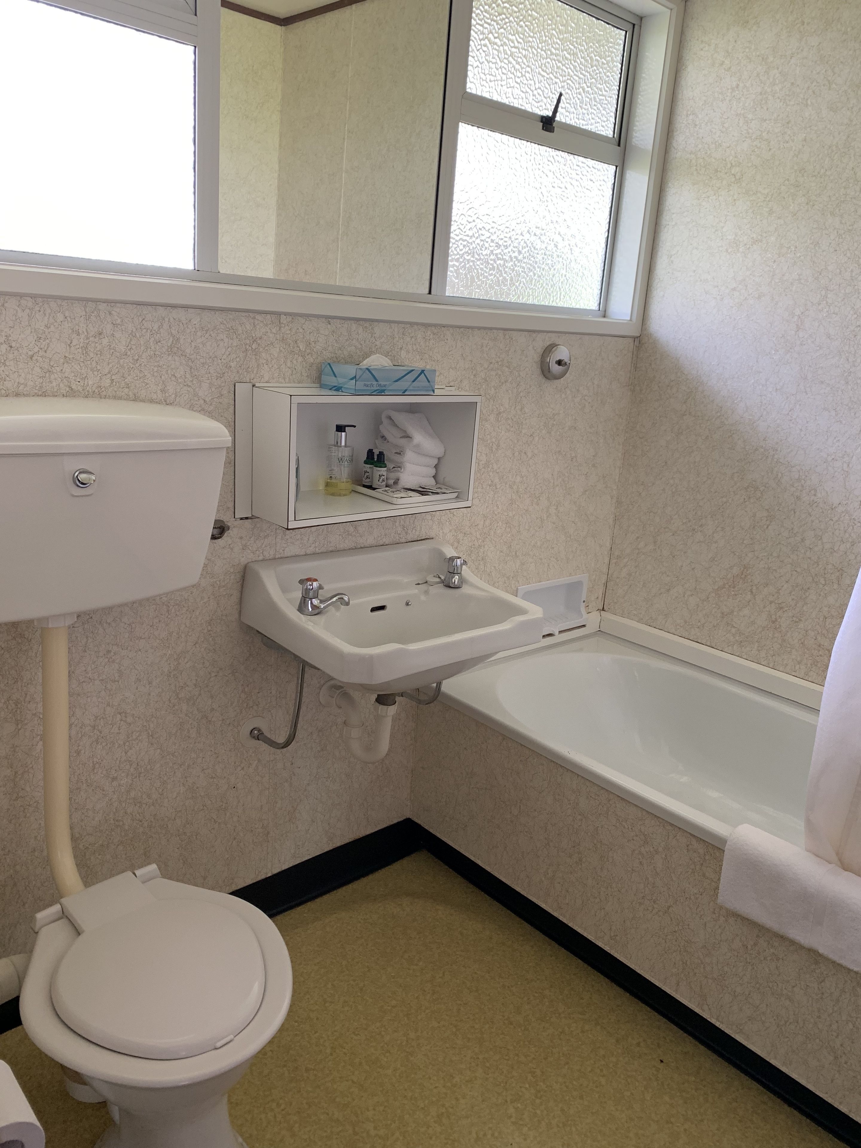 Un baño con inodoro, lavabo y bañera.