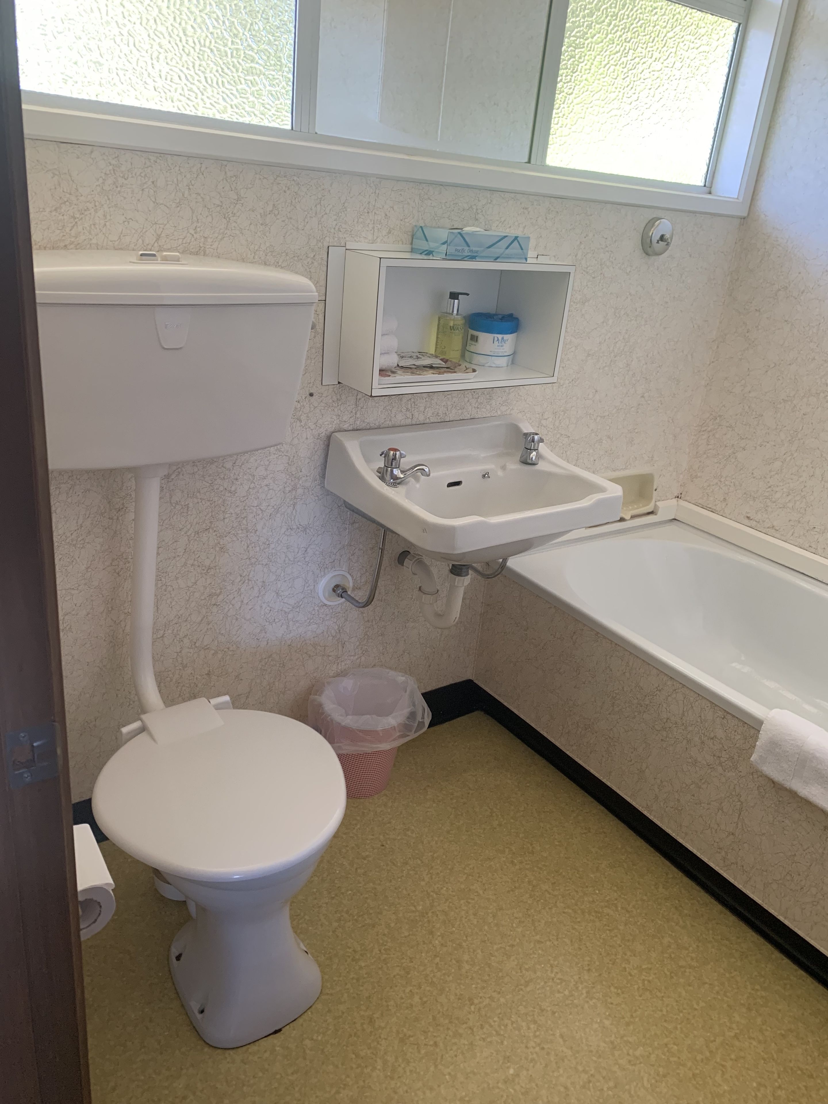 A bathroom with a toilet, sink, and bathtub.