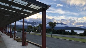 A covered outdoor area with a view of mountains and a lake. - Te Anau Manapouri Lake Hotel (Manapouri)
