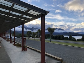 Un espacio al aire libre techado con vistas a montañas y un lago.
