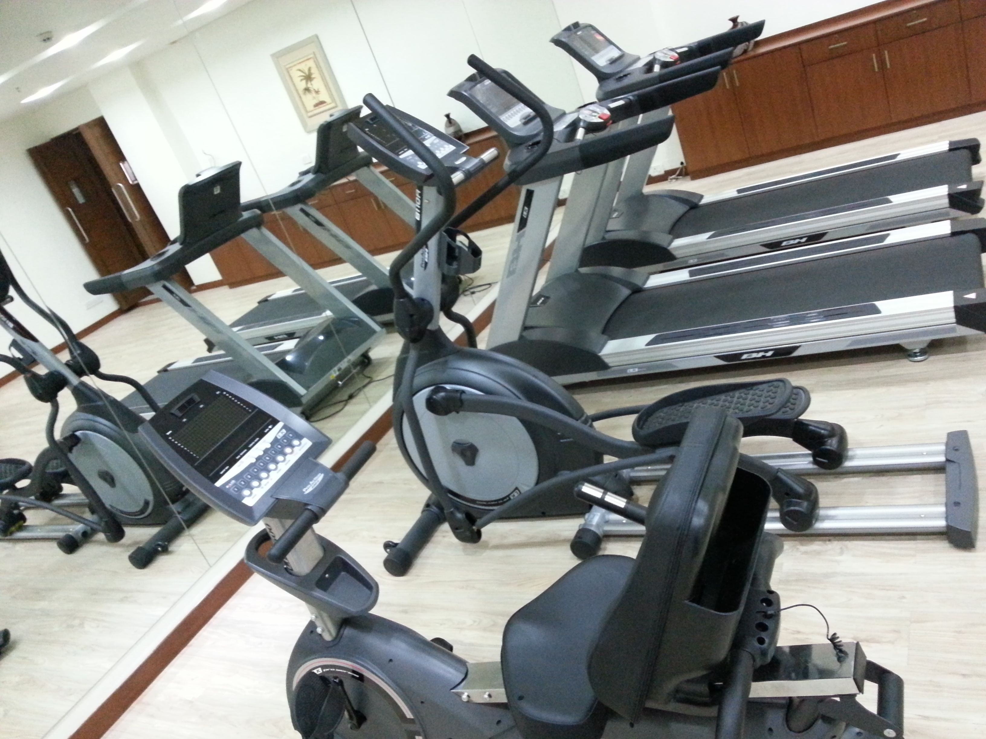 A gym with multiple exercise machines, including treadmills and stationary bikes.
