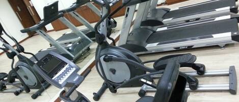 A gym with multiple exercise machines, including treadmills and stationary bikes.
