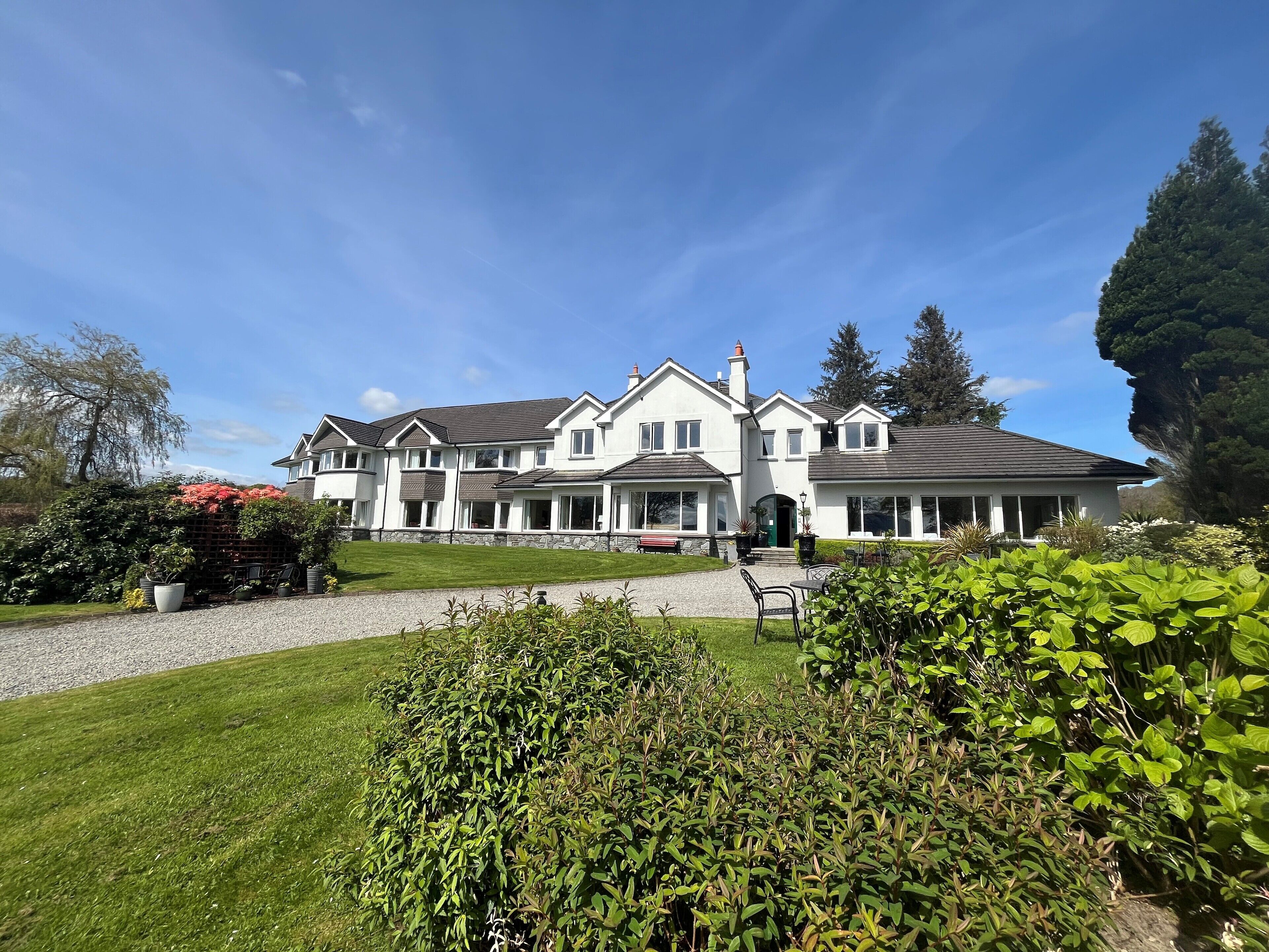 Ein großes, zweistöckiges Haus mit gepflegtem Rasen und Garten.