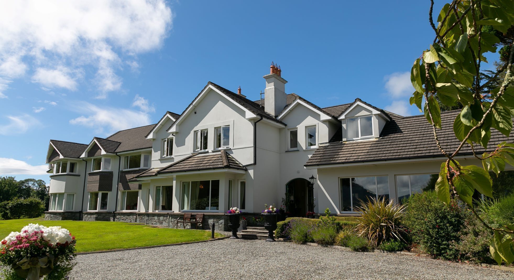 A two-story house with a symmetrical facade, multiple windows, and a well-maintained lawn.