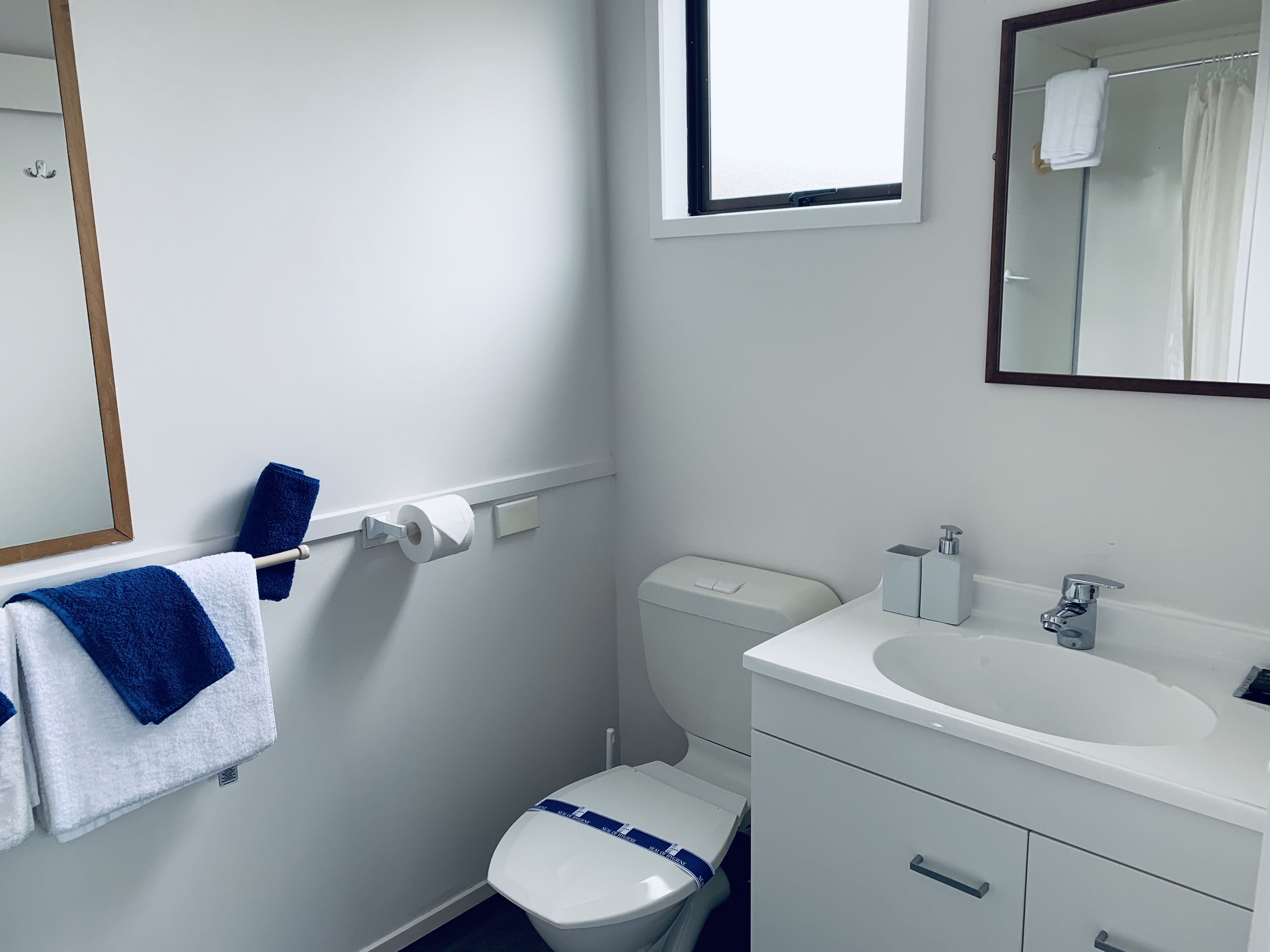 Un baño pequeño y limpio con inodoro, lavabo y espejo.
