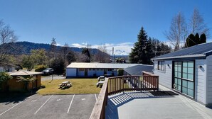 Un hotel con estacionamiento, mesas de picnic y vistas a las montañas.