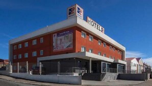 Un hotel rojo y blanco con un letrero que dice "HOTEL 2" y un cartel anunciando "Hotel & Restaurante".