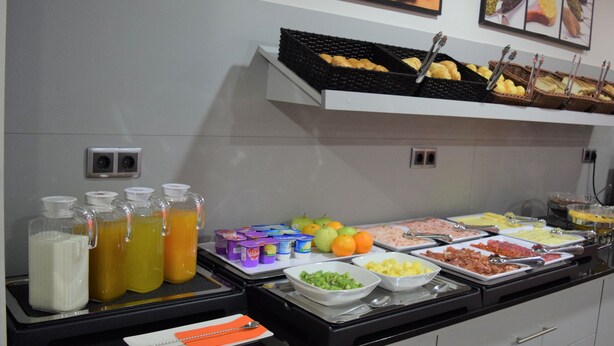 Un bufé con diversas opciones de comida y bebidas.