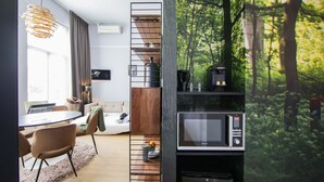Ett modernt kök med en inbyggd mikrovågsugn och ett stort fönster med utsikt över skogen.