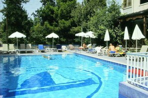 Piscine extérieure en saison, parasols, chaises longues