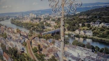A panoramic view of a town with a river, a bridge, and a metal structure in the foreground.