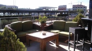 An outdoor seating area with wicker furniture, a table, and a view of the cityscape. - Hotel Torre DE Sila (Tordesillas)