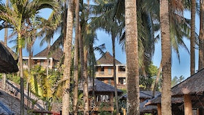A pathway lined with palm trees leading to a building with a thatched roof. - Fridays Boracay Resort (Boracay Island)