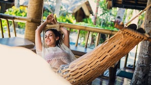 A hammock chair with a woven seat and backrest, suspended between two wooden posts. - Fridays Boracay Resort (Boracay Island)