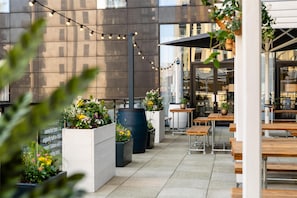 Relax in a stylish urban setting with comfortable seating and lush greenery.