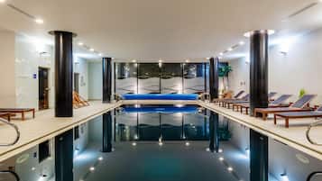 Una piscina techada, sillones reclinables de piscina