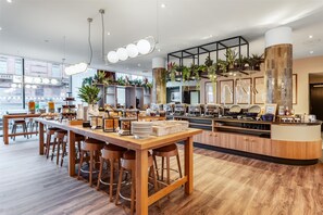 Enjoy a casual dining experience at this restaurant with a central island, plants, and a view of the street outside.