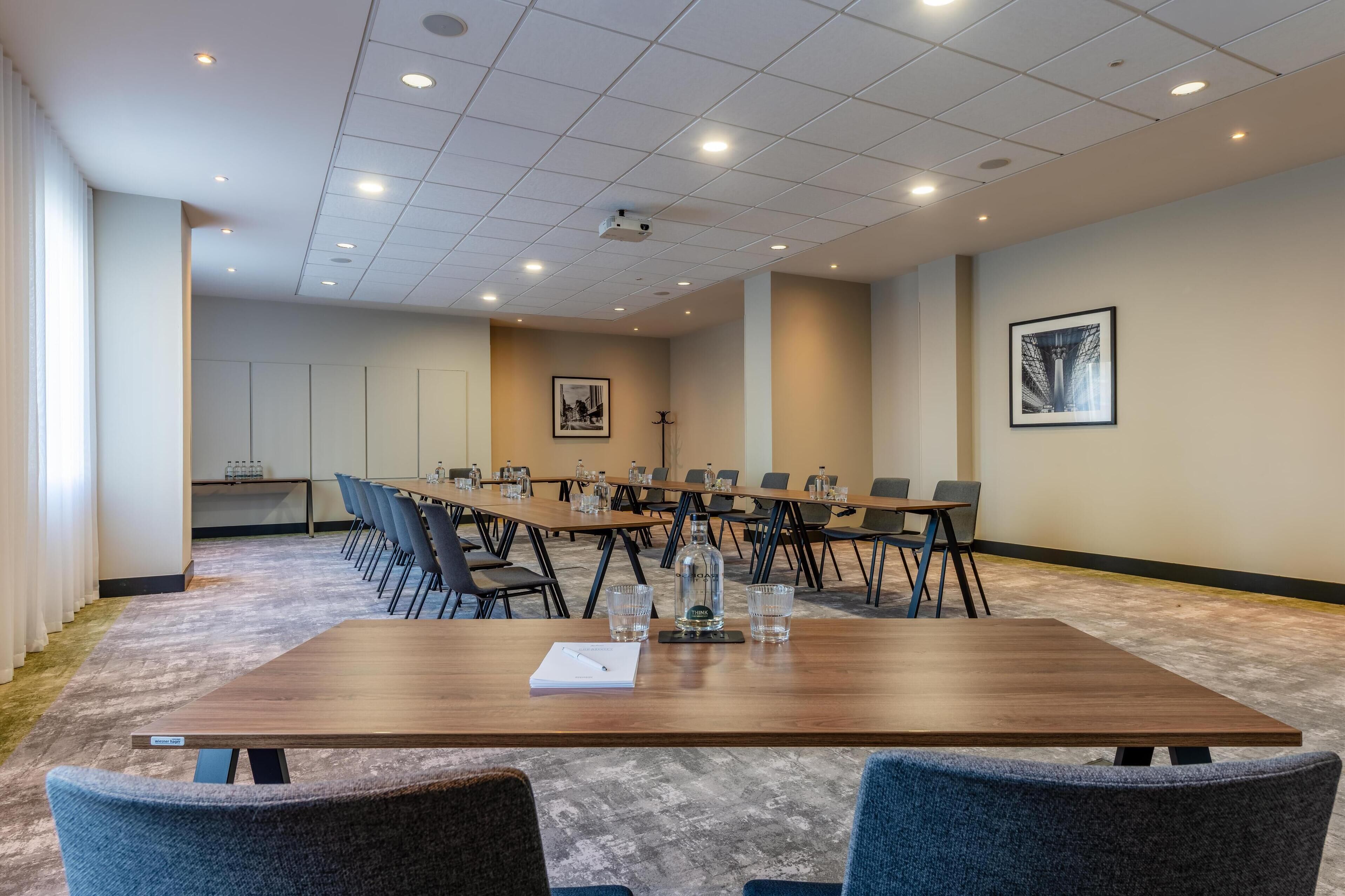 A conference room with a long table, chairs, and a projector.