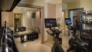A home gym with exercise equipment, including treadmills, a stationary bike, and weights.