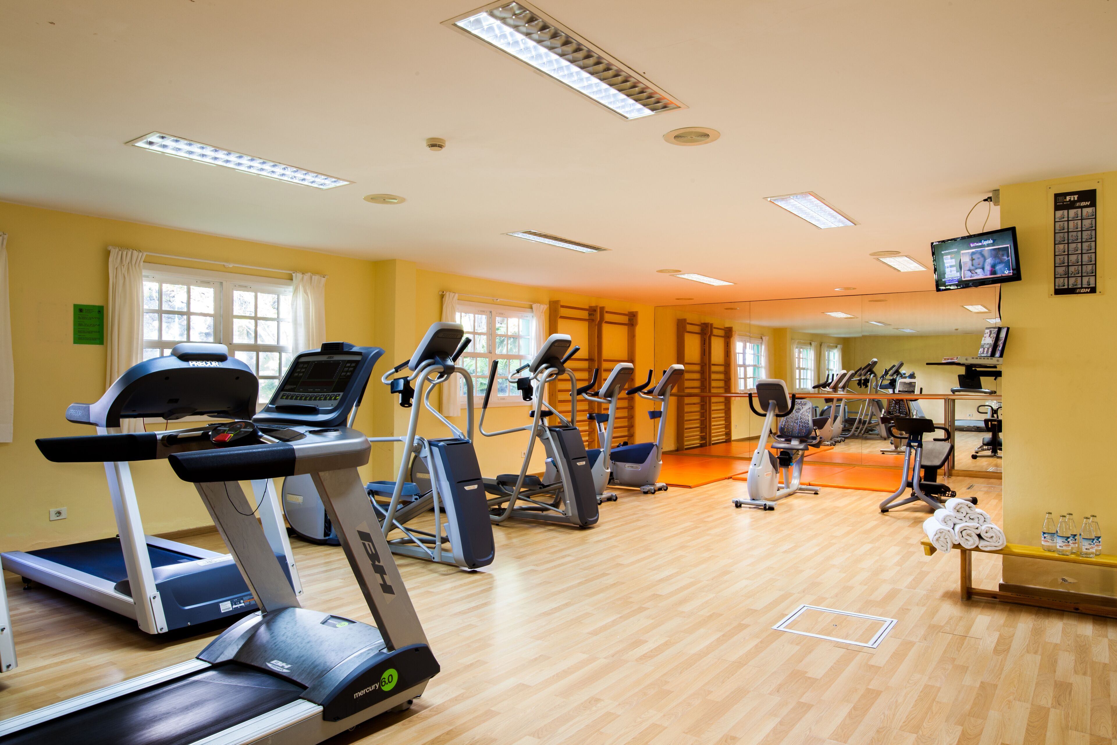 Una palestra con tapis roulant, ellittiche e cyclette.