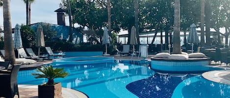 季節性室外游泳池,提供泳池遮陽傘和日光浴躺椅