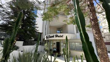 Hotel di design chiamato "Sukh Hotel", con un giardino di cactus di fronte.