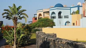 Un edificio a più piani con un mix di stili architettonici, tra cui una cupola blu e finestre ad arco.