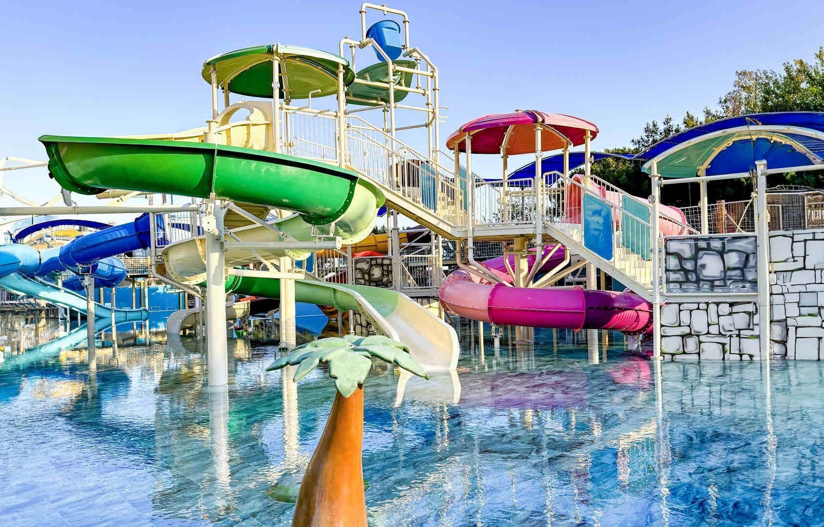Un parco acquatico con diverse scivoli e una zona piscina.
