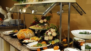 A buffet with various dishes and a decorative centerpiece. - Sealine Hotel (Alanya)