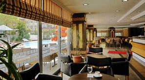 A hotel lobby with a pool view, dining area, and bar. - Sealine Hotel (Alanya)