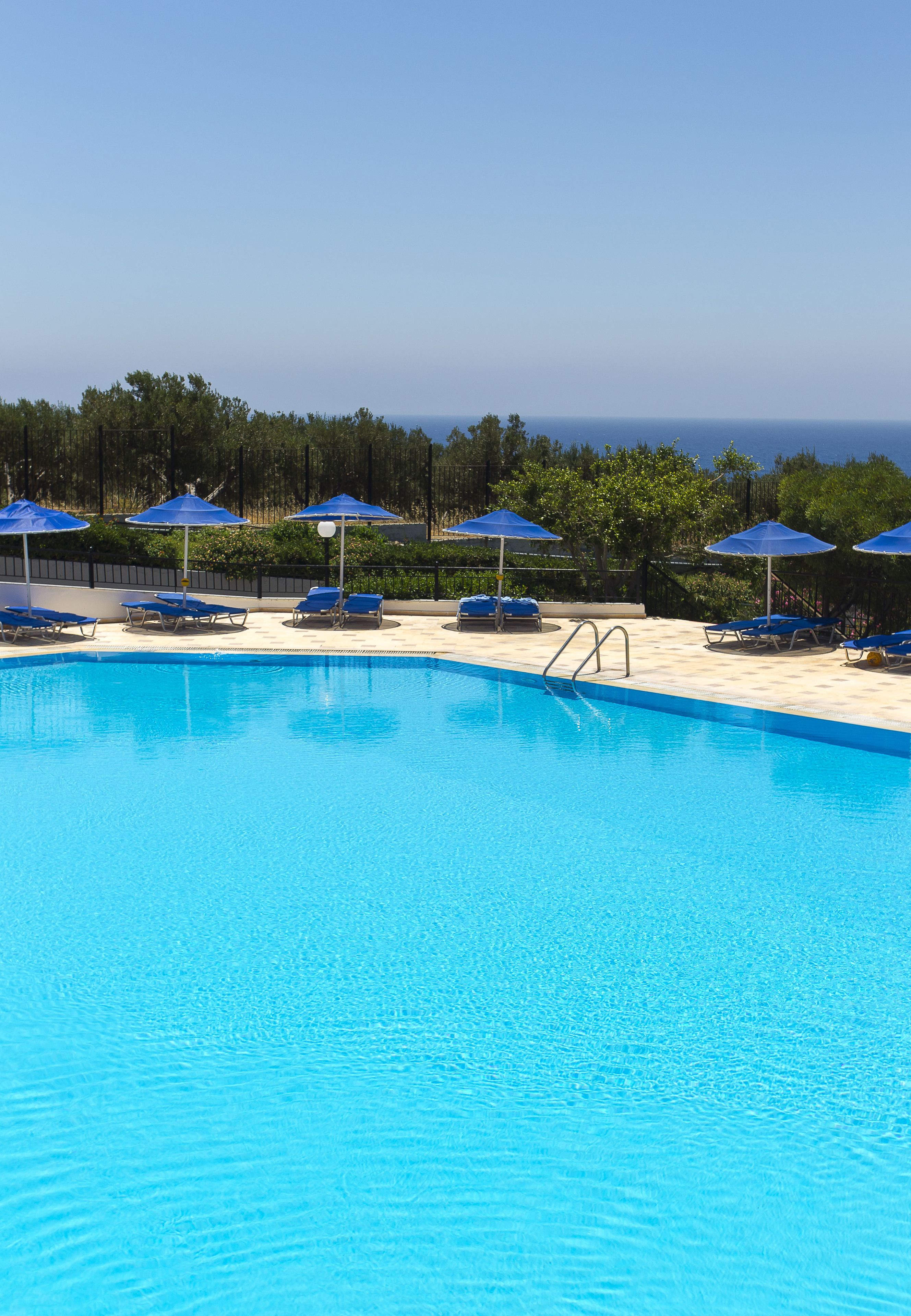 Alberca al aire libre, sombrillas en la alberca y camastros 