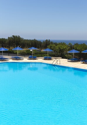 Piscine extérieure, parasols de plage, chaises longues