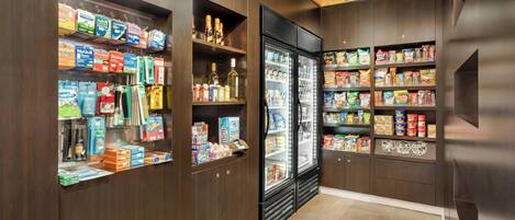 Un magasin dont les étagères sont remplies de divers produits, notamment des collations, des boissons et des articles ménagers.