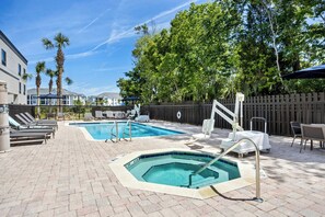 A pool area with two pools, lounge chairs, and a hot tub. - Courtyard by Marriott St Augustine I-95 (St. Augustine)