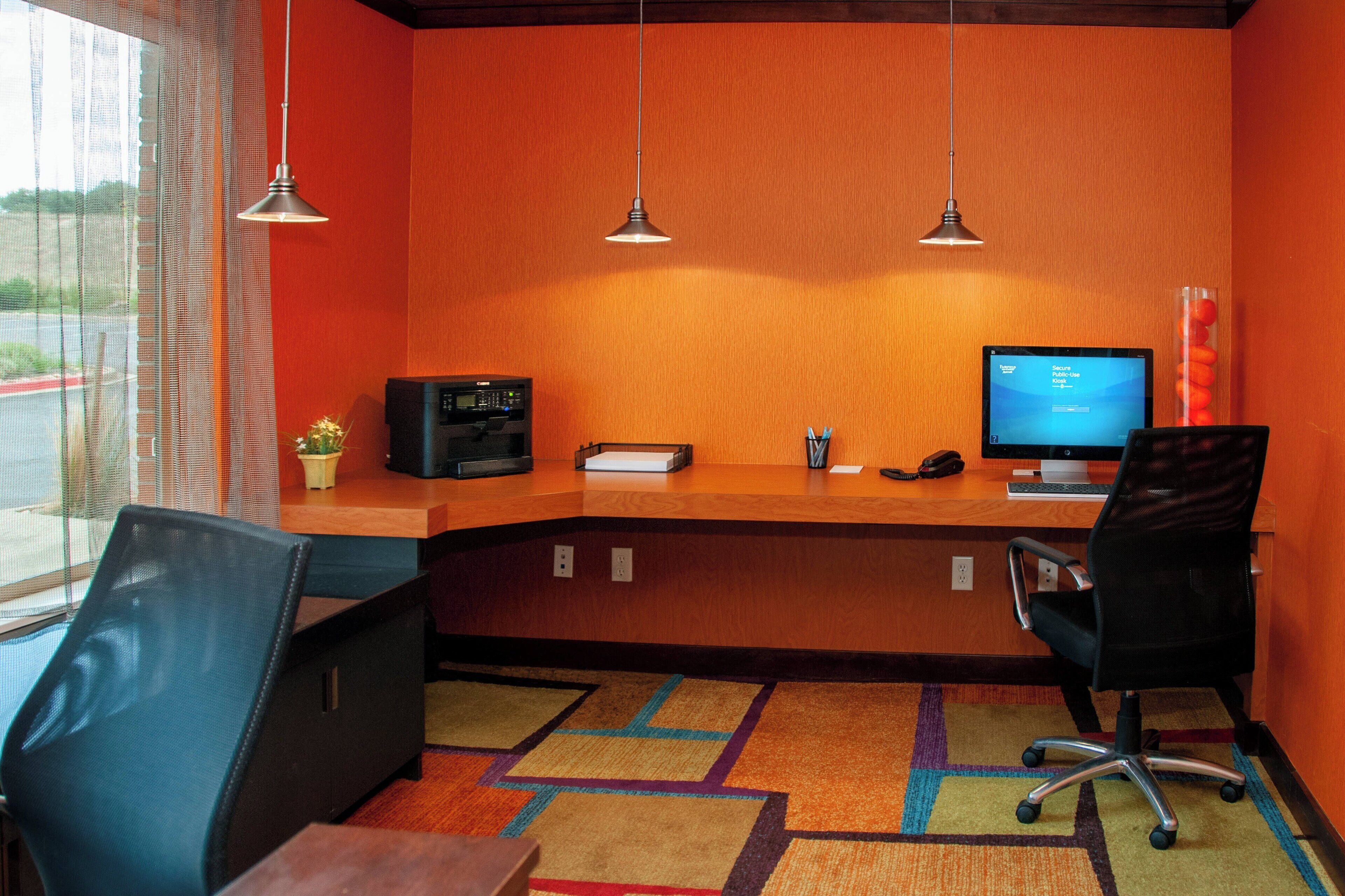 A reception area with a desk, two chairs, a computer, and a telephone.