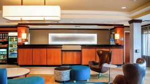 A hotel lobby with a reception desk, seating area, and a minibar. - Fairfield Inn & Suites Colorado Springs N./Air Force Academy (Colorado Springs)