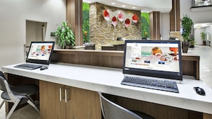 A reception desk with two laptops, a computer mouse, and a chair. - Embassy Suites Columbus-Airport (Columbus)