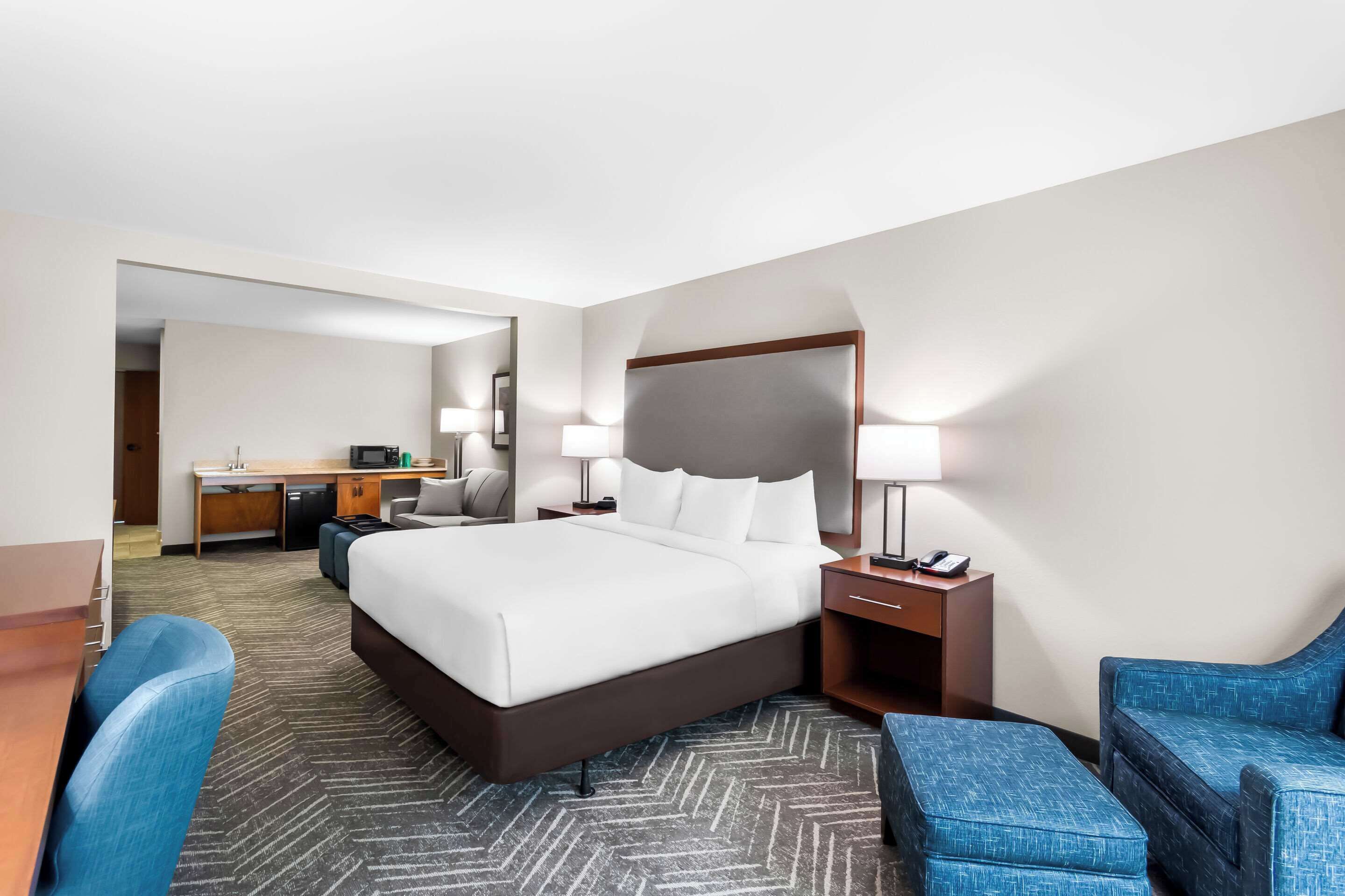 Une chambre d’hôtel avec un grand lit, un bureau, une chaise et un canapé.