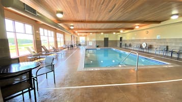 Relax by the pool surrounded by lounge chairs and tables.