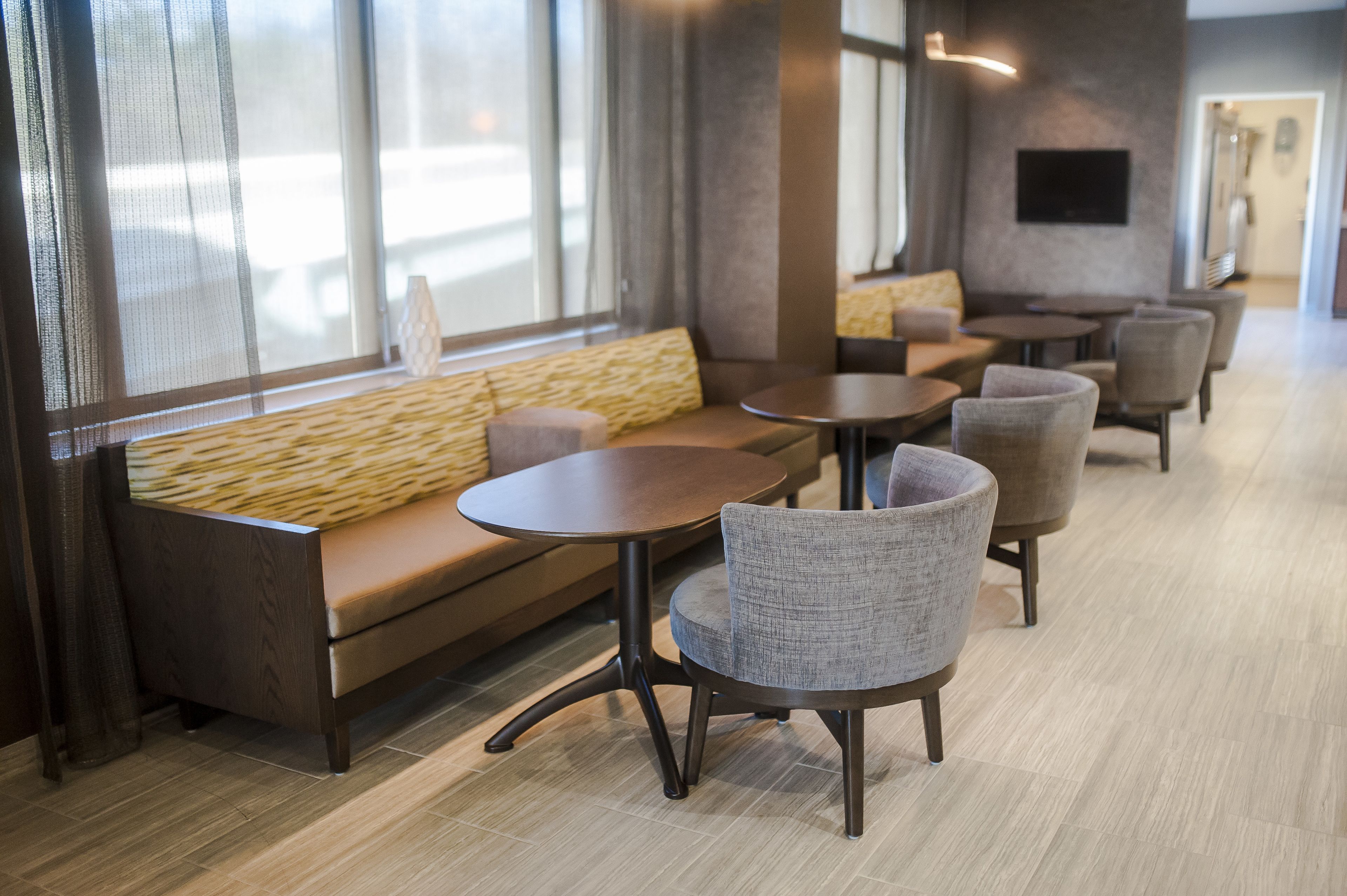 A modern interior with a sofa, chairs, and tables arranged for seating.
