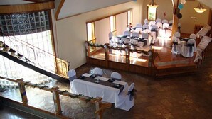A spacious hall with tables set for a banquet, large windows, and a staircase leading to an upper level. - The Inn at Plantation (Jane Lew)