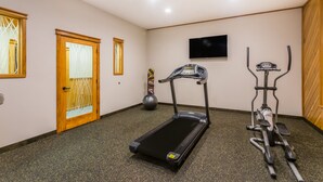 A home gym with a treadmill, elliptical, and exercise ball. - The Inn at Plantation (Jane Lew)