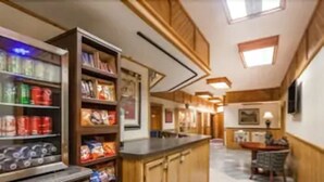 A kitchen with wooden cabinets, a countertop, and a tiled floor. - The Inn at Plantation (Jane Lew)