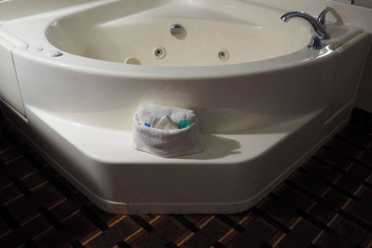 A white bathtub with a small towel and toiletries.