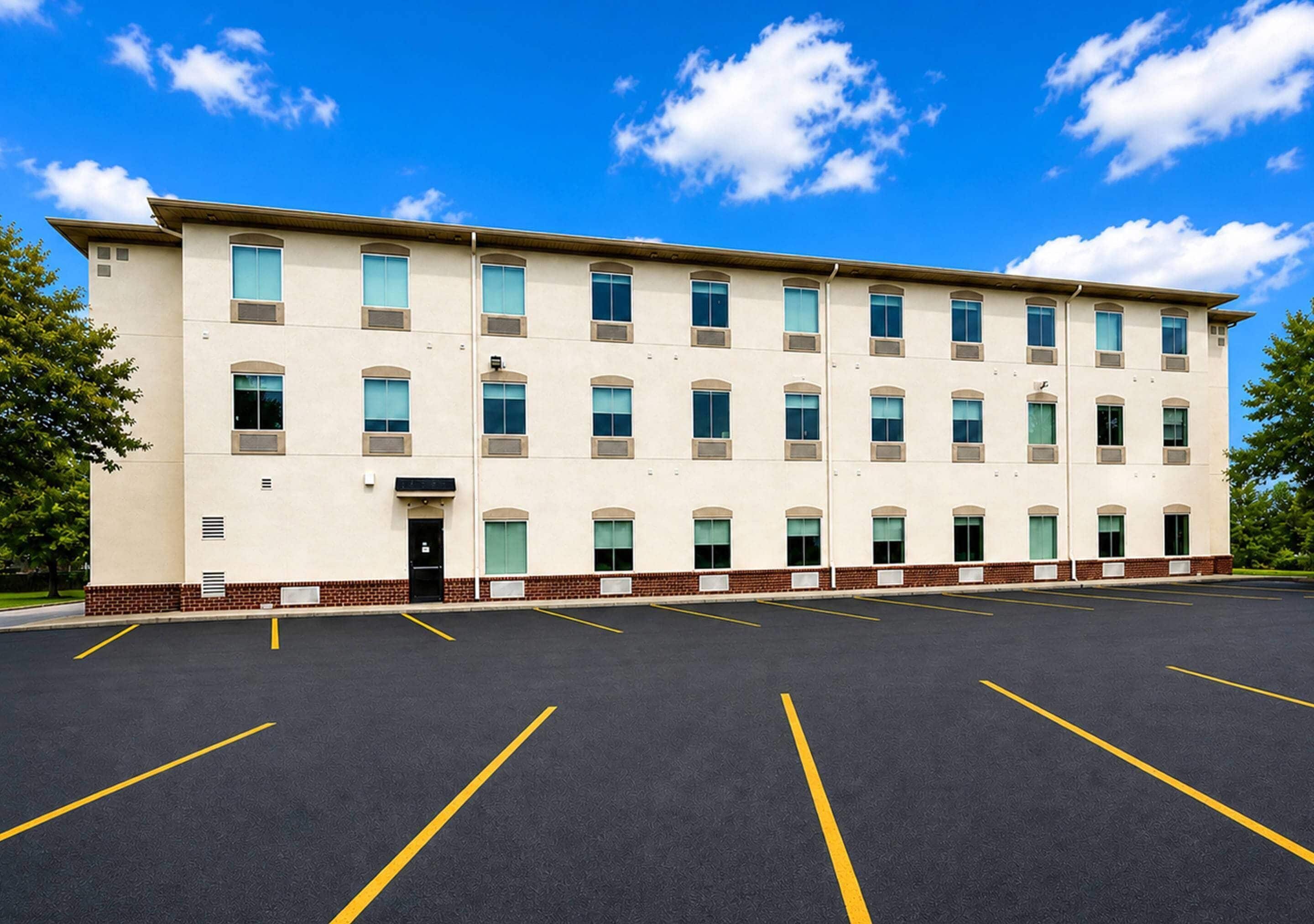 A multi-story building with a parking lot in front.
