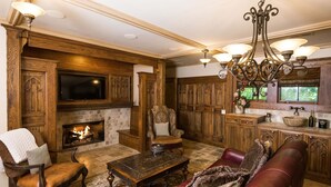 A traditional living room with a fireplace, leather furniture, and wooden cabinetry. - 1900 Inn on Montford (Asheville)